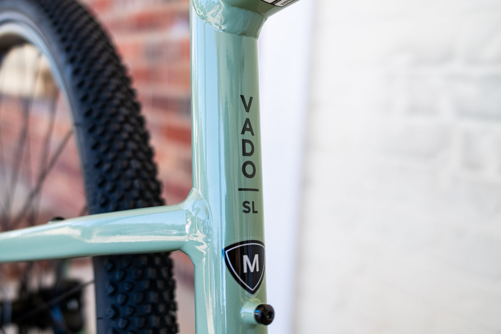 Close-up of the VADO SL decal and a size M badge on the sage green frame